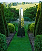 DAVID HARBER SUNDIALS. STAINLESS STEEL OBELISK SUNDIAL ON GRASS PATH WITH YEW TOPIARY  AT PETTIFERS  OXFORDSHIRE. FORMAL GARDEN