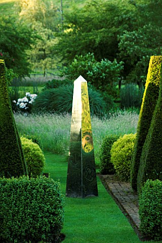 DAVID_HARBER_SUNDIALS_STAINLESS_STEEL_MIRRORED_OBELISK_SUNDIAL_ON_GRASS_PATH_WITH_YEW_TOPIARY_AT_PET