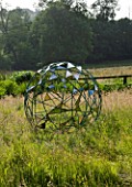 DAVID HARBER SUNDIALS: NUAGE SPHERICAL STAINLESS STEEL METAL SCULPTURE IN THE MEADOW AT PETTIFERS GARDEN  OXFORDSHIRE