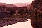 THE RIVER AND RAILWAY BRIDGE IN THE EVENING AT ANDUZE  PROVENCE  FRANCE. THE TRAIN STOPS AT THE BAMBOUSERAIE DE PRAFRANCE