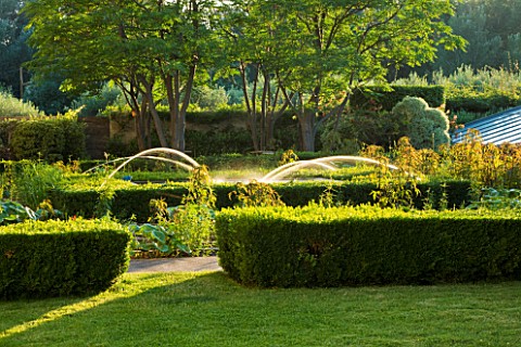 CHATEAU_PLAISIR__FRANCE__DESIGNER_PASCAL_CRIBIER__THE_WATER_GARDEN_BESIDE_THE_CHATEAU_IN_EVENING_LIG