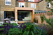 GARDEN DESIGNER: CHARLOTTE ROWE  LONDON: FORMAL TOWN/CITY GARDEN. VIEW TOWARDS HOUSE WITH GLASS & TIMBER EXTENSION AND DINING AREA