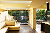 GARDEN DESIGNER: CHARLOTTE ROWE  LONDON: INTERIOR OF EXTENSION LOOKING OUT ONTO FORMAL TOWN/CITY GARDEN