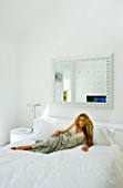 TANIA LAURIE  LONDON. TANIA RELAXES ON HER BED IN HER WHITE-THEMED BEDROOM