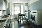 TANIA LAURIE  LONDON. CONTEMPORARY KITCHEN WITH BLACK UNITS  DOUBLE OVENS AND BREAKFAST BAR