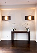 TANIA LAURIE  LONDON. HALLWAY WITH TABLE AND ORCHIDS WITH CONTEMPORARY LIGHTING