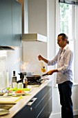 TANIA LAURIE  LONDON. TANIAS PARTNER DANIEL COOKING LUNCH IN THEIR STYLISH  CONTEMPORARY KITCHEN