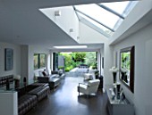TANIA LAURIE  LONDON. INTERIOR OF LIVING / DINING AREA WITH ROOFLIGHT LEADING OUT ONTO CONTEMPORARY GARDEN DESIGNED BY CHARLOTTE ROWE