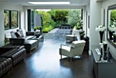 TANIA LAURIE  LONDON. INTERIOR OF LIVING / DINING AREA LEADING OUT ONTO PATIO AND CONTEMPORARY GARDEN DESIGNED BY CHARLOTTE ROWE