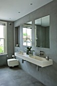 TANIA LAURIE  LONDON. WALL MOUNTED DOUBLE STONE SINK IN GREY SLATE TILED BATHROOM WITH MIRRORS