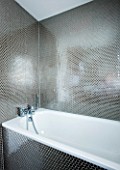 TANIA LAURIE  LONDON. STYLISH  CONTEMPORARY BATHROOM WITH WHITE BATH AND SILVER HONEYCOMB EFFECT MOSAIC TILES