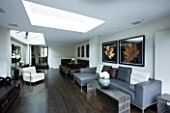 TANIA LAURIE  LONDON. INTERIOR OF LIVING / DINING AREA WITH LEATHER SOFAS  WHITE CHAIR AND ROOFLIGHT