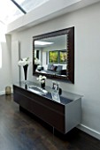 TANIA LAURIE  LONDON. INTERIOR OF LIVING AREA WITH CONTEMPORARY SIDEBOARD AND MIRROR