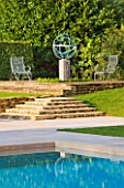 DAVID HARBER SUNDIALS: ARMILLARY SPHERE SUNDIAL AND SWIMMING POOL WITH STONE STEPS AND METAL CHAIRS