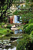 GARDEN OF ERIK BORJA  FRANCE: JAPANESE/ ASIAN STYLE - VIEW TO THE EAST SIDE OF THE HOUSE WITH BLUE SHUTTERS  POLL/ POND  GRAVEL GARDEN  ROCKS  CLIPPED SCOTS PINE