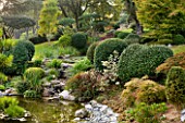 GARDEN OF ERIK BORJA  FRANCE: THE WATER GARDEN WITH LARGE POND/ POOL  ROCKS  WATERLILIES AND CLIPPED TOPIARY SHAPES. WATERFALL