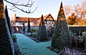 WOLLERTON OLD HALL  SHROPSHIRE: WINTER GARDEN IN FROST -  THE YEW WALK: PATH TO THE HOUSE AT DAWN WITH CLIPPED PYRAMID TOPIARY YEWS
