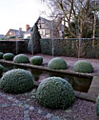 WOLLERTON OLD HALL  SHROPSHIRE: WINTER GARDEN IN FROST -  THE RILL GARDEN -  A WIDE CANAL LINED WITH BOX TOPIARY BALLS AND FASTIGATE CARPINUS WITH THE HOUSE BEHIND