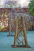 WOLLERTON OLD HALL  SHROPSHIRE: WINTER GARDEN IN FROST -  BEAUTIFUL OAK TRIPODS FOR CLIMBING PLANTS IN THE OLD GARDEN BY THE BACK OF THE HOUSE. DAWN LIGHT