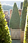 WOLLERTON OLD HALL  SHROPSHIRE: WINTER GARDEN IN FROST -  VERSAILLES CONTAINERS PLANTED WITH CLIPPED TOPIARY BOX PYRAMIDS
