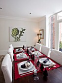 WHITE DINING ROOM WITH DINING TABLE  WHITE CHAIRS.  LAID UP FOR CHRISTMAS. SARAH EASTEL LOCATIONS/ DI ABLEWHITE