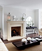 CHRISTMAS - LIVING ROOM WITH CREAM FIREPLACE  CREAM SOFA  WOODEN COFFEE TABLE  SILVER GLOBES  MIRROR. SARAH EASTEL LOCATIONS/ DI ABLEWHITE