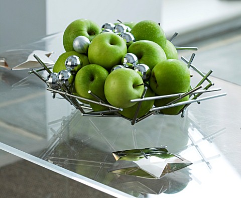 CHRISTMAS__SILVER_MATAL_DISH_WITH_GREEN_APPLES_AND_SILVER_BAUBLES_ON_A_GLASS_COFFEE_TABLE_SARAH_EAST