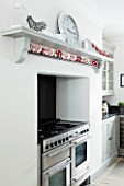 CHRISTMAS -DETAIL OF BLACK COOKER AND WHITE WALLS IN THE KITCHEN. SARAH EASTEL LOCATIONS/ DI ABLEWHITE