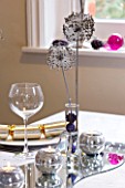 CLARE MATTHEWS CHRISTMAS HOUSE INTERIOR: TABLE WITH SILVER CANDLES ON MIRROR  GLASS WITH BAUBLES AND DRIED ALLIUMS  WINE GLASS AND PLATE WITH CRACKER