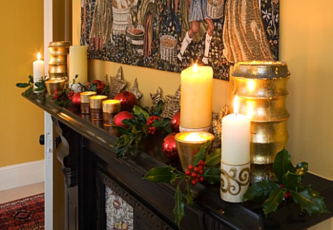 CLARE_MATTHEWS_CHRISTMAS_HOUSE_INTERIOR_THE_DINING_ROOM__CANDLES__BAUBLES__HOLLY_AND_TAPESTRY_ABOVE_