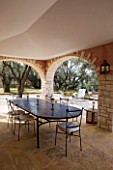 DESIGNER GINA PRICE - CORFU - VILLA ONEIRO - LARGE SHADED DINING AREA WITH TABLE AND LOUNGERS BEYOND