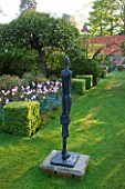 PASHLEY MANOR GARDEN  EAST SUSSEX  SPRING : THE BOX GARDEN PLANTED WITH THE PINK FLOWERS OF TULIP PINK DIAMOND  AND BLUE FORGET-ME-NOTS - SCULPTURE BY HELEN SINCLAIR