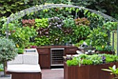 CHELSEA FLOWER SHOW 2009: FRESHLY PREPPED GARDEN BY ARALIA. OUTDOOR KITCHEN/ENTERTAINING AREA WITH EDIBLE LIVING WALL PLANTED WITH BABY SALAD LEAVES
