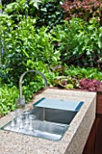 CHELSEA FLOWER SHOW 2009: FRESHLY PREPPED GARDEN BY ARALIA. STONE SINK AREA IN OUTDOOR KITCHEN SURROUNDED BY EDIBLE LIVING WALL PLANTED WITH BABY SALAD LEAVES
