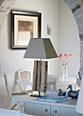 DESIGNER: CLAIRE SKINNER  ROU ESTATE  CORFU: HOUSE 11 (LAVENDULA) INTERIOR - LIVING ROOM IN GREY  CREAM AND PINK. CENTRANTHUS IN VASE  ARCH AND LAMP