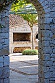 PRIVATE VILLA  CORFU  GREECE. DESIGN BY ALITHEA JOHNS - VIEW THROUGH ARCHWAY TO WOOD STORE