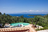 VILLA ONEIRO  CORFU  DESIGNER GINA PRICE: VIEW ACROSS THE SWIMMING POOL WITH SUN LOUNGERS FROM MOROCCO AND VIEW TO ALBANIA