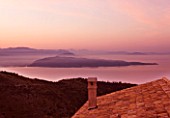 THE ROU ESTATE  CORFU: DAWN VIEW OVER ROOFTOP TO SEA AND ALBANIAN MOUNTAINS