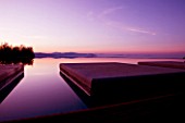THE ROU ESTATE  CORFU: THE SWIMMING POOL AT DAWN WITH THE ALBANIAN MOUNTAINS BEHIND