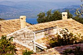 THE ROU ESTATE  CORFU: TILED ROOFS WITH SEA AND ALBANIA BEYOND