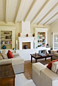 THE ROU ESTATE  CORFU: SITTING/LIVING ROOM WITH RAISED FIREPLACE  SOFAS AND BOOKSHELVES