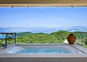 THE KAPARELLI ESTATE  CORFU - UNDERCOVER JACUZZI/HOT TUB ON RAISED PATIO WITH VIEW OUT TO SEA WITH ALBANIAN MOUNTAINS BEYOND