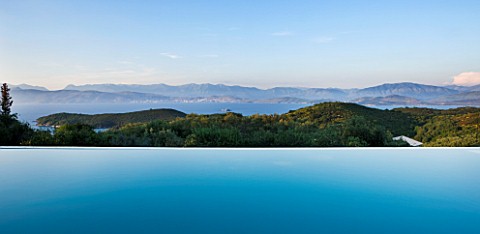 THE_KAPARELLI_ESTATE__CORFU__VIEW_OVER_INFINITY_SWIMMING_POOL_OUT_TO_SEA_WITH_ALBANIAN_MOUNTAINS_BEY