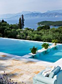 THE KAPARELLI ESTATE  CORFU - PATIO/SEATING AREA WITH VIEW OVER SWIMMING POOL OUT TO SEA WITH ALBANIAN MOUNTAINS BEYOND