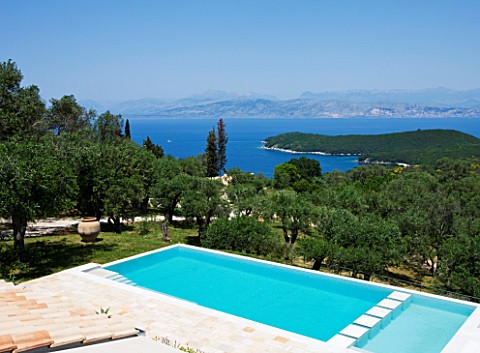 THE_KAPARELLI_ESTATE__CORFU__VIEW_OVER_SWIMMING_POOL_OUT_TO_SEA_WITH_ALBANIAN_MOUNTAINS_BEYOND