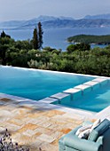 THE KAPARELLI ESTATE  CORFU - VIEW OVER PATIO AND SWIMMING POOL OUT TO SEA WITH ALBANIAN MOUNTAINS BEYOND