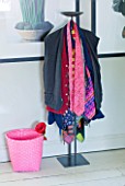 PAULA PRYKES HOUSE  SUFFOLK: CLOTHES STAND IN BEDROOM LAYERED WITH CLOTHES