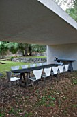 JACQUELINE MORABITO  FRANCE - DINING AREA - WHITE CONCRETE SEATING AREA WITH WOODEN TABLE AND WHITE CHAIRS