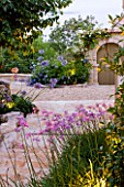 THE ROU ESTATE  CORFU  GREECE: DESIGNER: DOMINIC SKINNER - MEDITTERANEAN STYLE GARDEN - STONE STEPS SURROUNDED BY AGAPANTHUS AND TULBAGHIA VIOLACEA