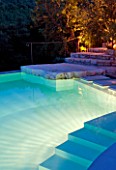 THE ROU ESTATE  CORFU  GREECE: DESIGNER: DOMINIC SKINNER - THE SWIMMING POOL AREA  LIT UP AT NIGHT WITH STEPS. LIGHTING